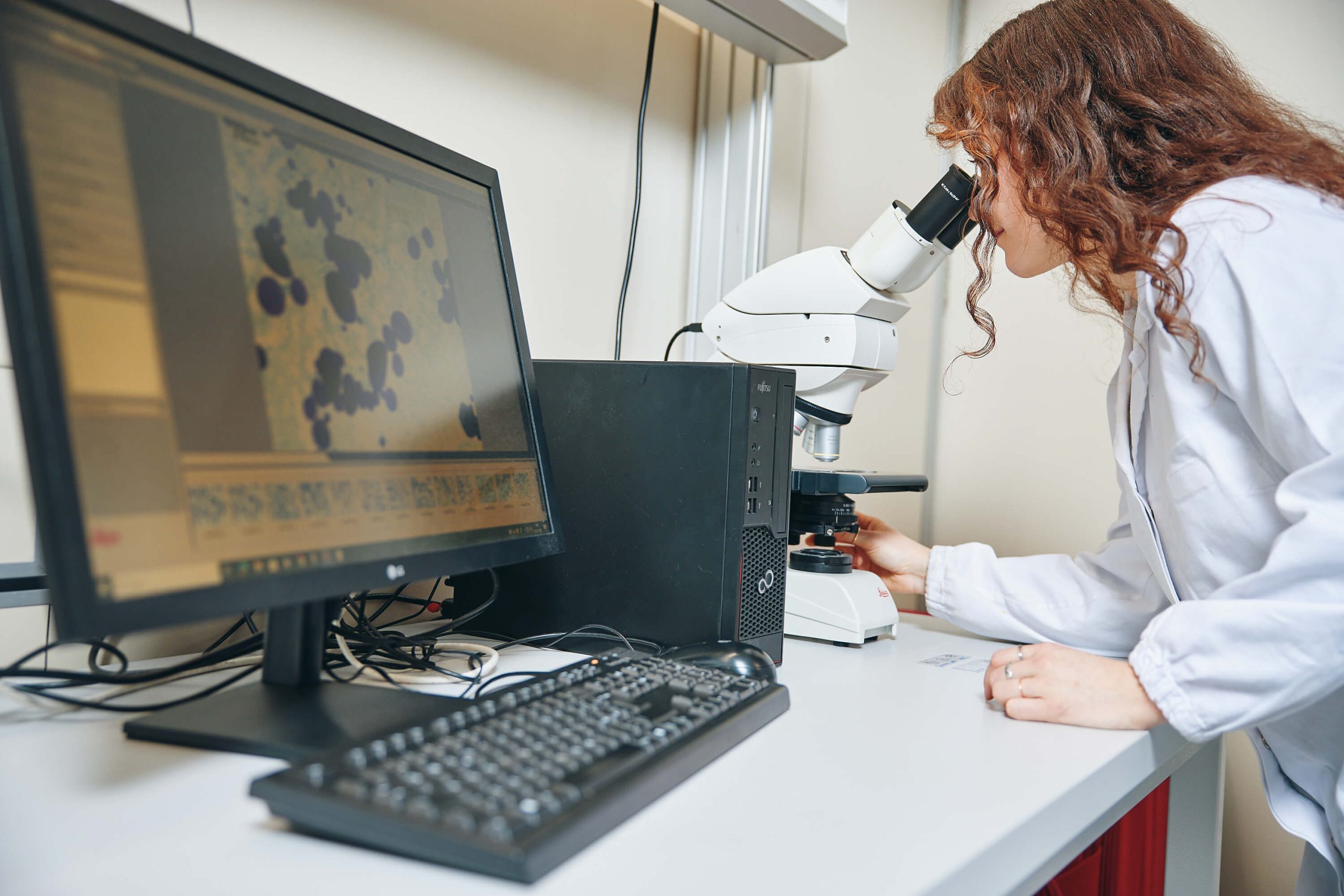 Tecnico in laboratorio alimentare con microscopio