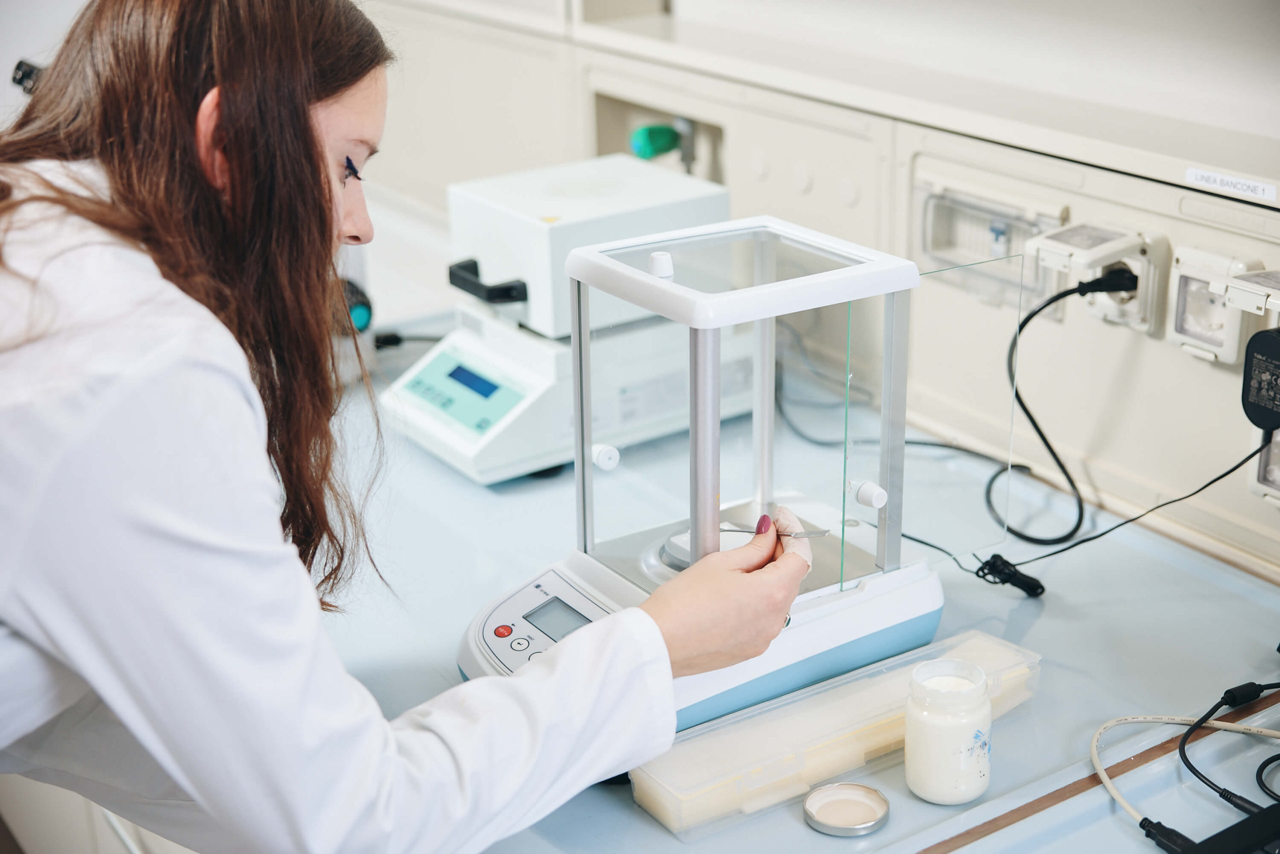 Pesatura ingredienti cosmetici su bilancia di precisione